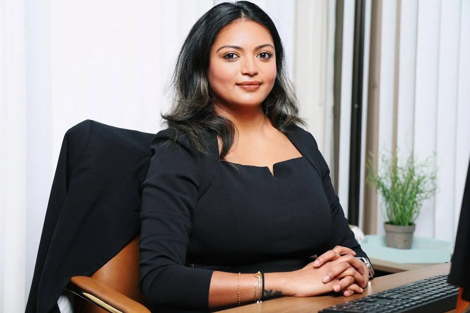 Attorney Roshni Patel seated at her desk in a professional setting, representing RPatel Law in Orlando, Florida